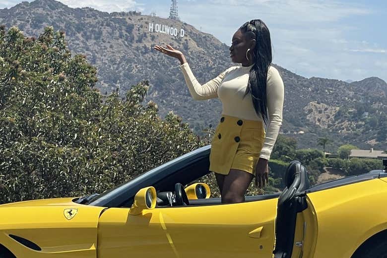 Posando ao lado do letreiro de Hollywood a bordo da Ferrari
